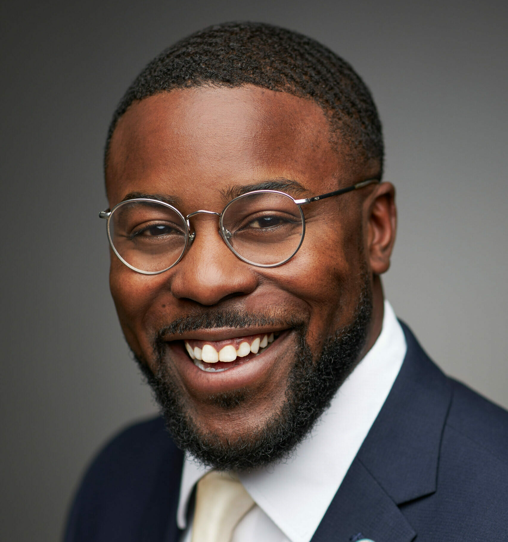 black man suit and glasses smiling