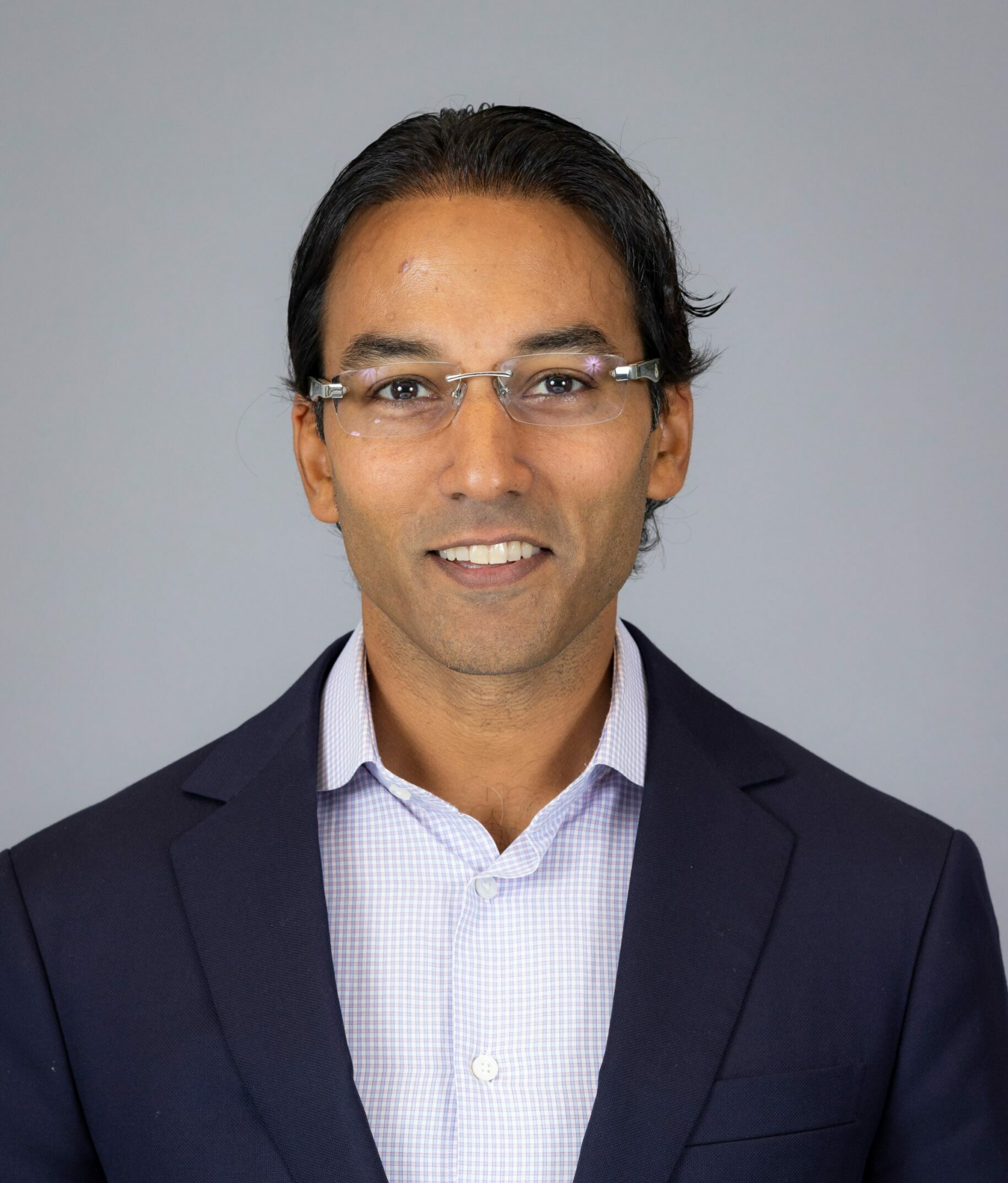 brown man in glasses and blue suit